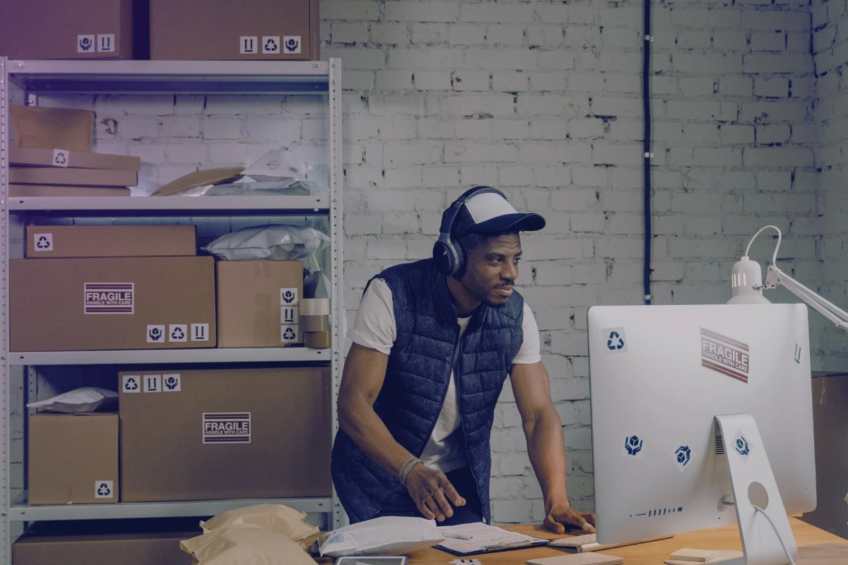 Thrift store owner working in a warehouse, picking and packing online orders for shipment.