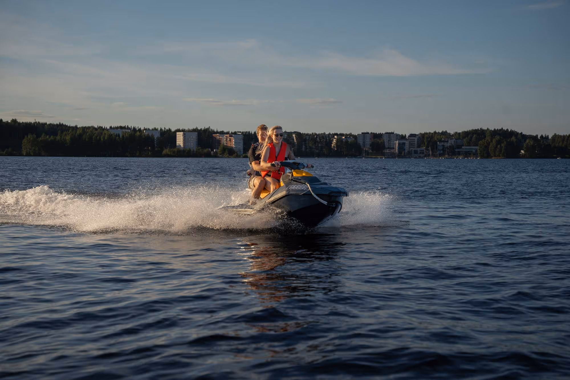 Two people riding a rental jet ski from laineille.fi, a Tampere based watersport and experience business.