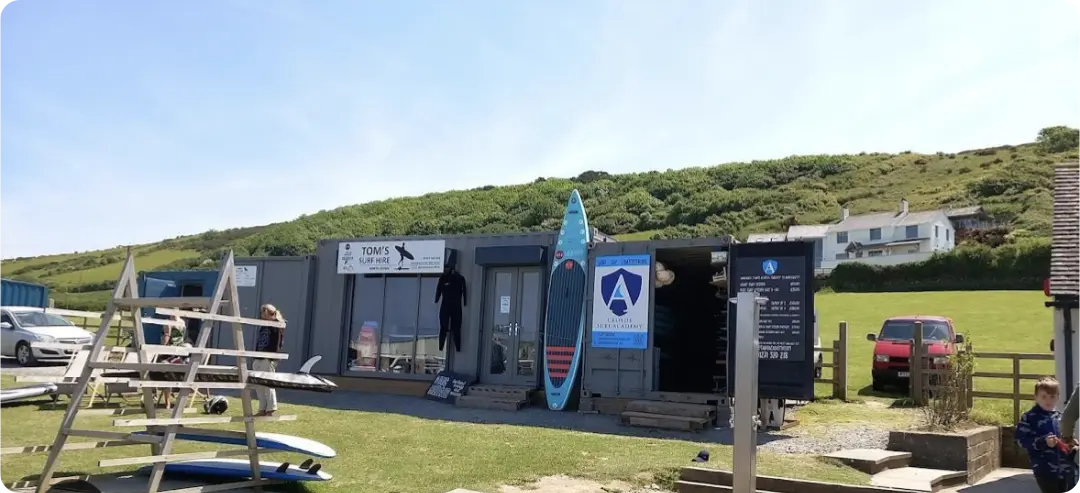 The rental depot of Tom's Surf Hire, located in the picturesque landscape of Croyde Bay.